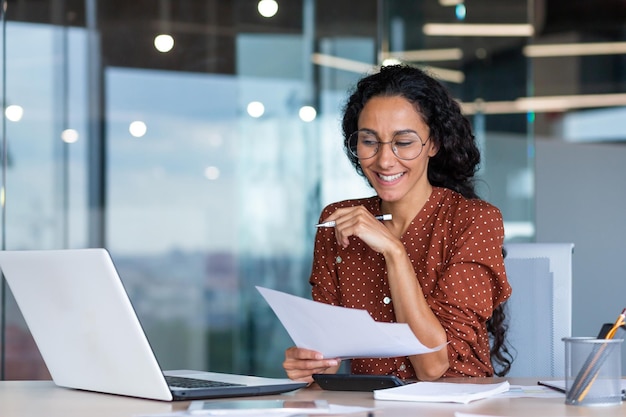 Successful satisfied and happy business woman working inside modern office hispanic woman in glasses