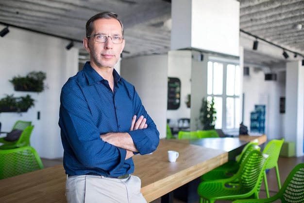 Photo successful senior businessman standing in office