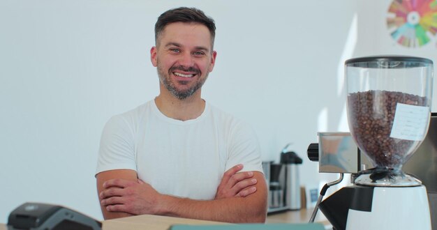 Successful small business owner man standing with crossed arms Portrait of young male cafe owner Coffee shop concept