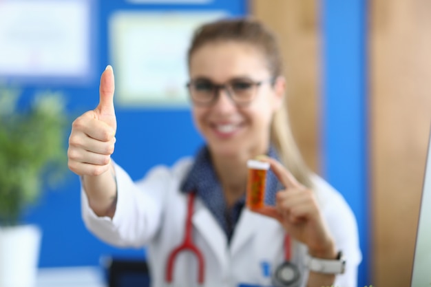 Successful smiling female doctor holding medicine in her hand