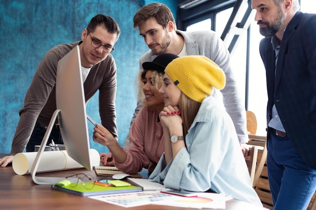 Successful team Group of young business people working and communicating together in creative office
