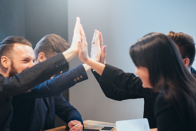 Lavoro di squadra e cooperazione di successo. giovane squadra di professionisti. partner commerciali maschili e femminili che danno il cinque.