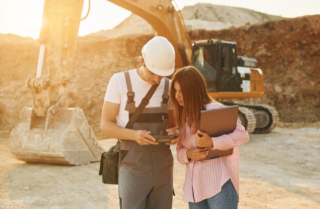 Photo successful teamwork two people is on the borrow pit at daytime together