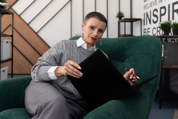 Successful woman broker with folders of papers in the office