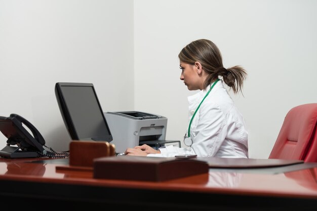 Photo successful woman doctor working at computer