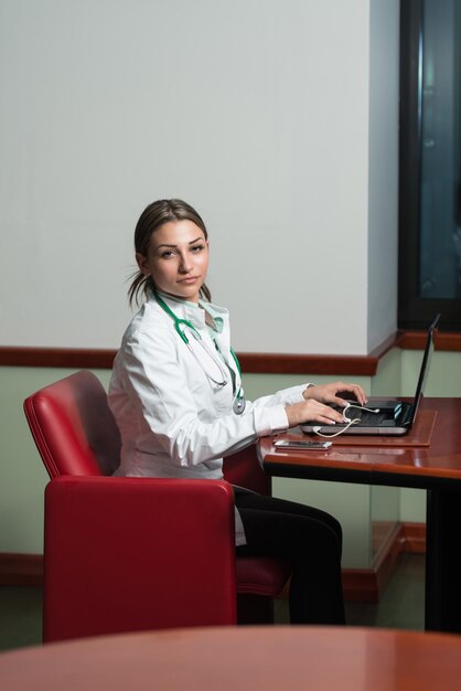 Photo successful woman doctor working at laptop