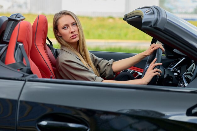 夢の車を買う喜びを抱いた成功した女性 豪華なカブリオレット