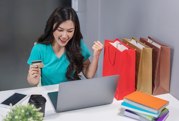 Successful woman using laptop computer for online shopping with credit card