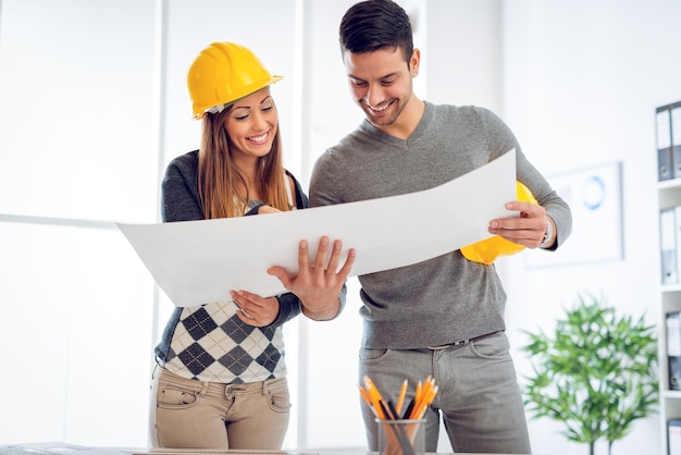 Premium Photo | Successful young architects discussing construction plans  and planning next step in office.