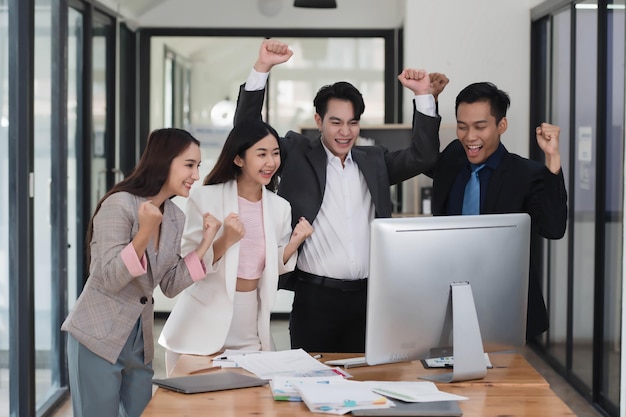 Successful young Asian business team feeling excited and happy from the good news