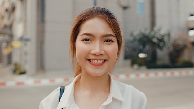 Successful young asian businesswoman in fashion office clothes smiling in the street