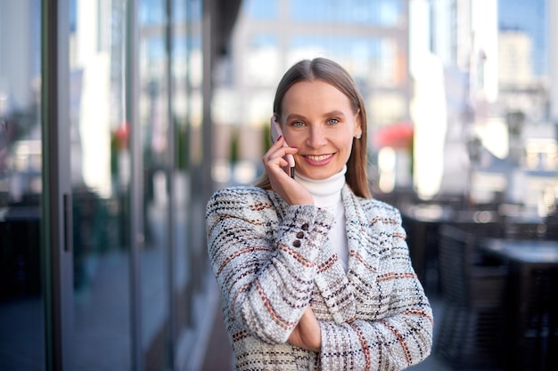 Successful young business woman confident looking at the camera and speaks on phone