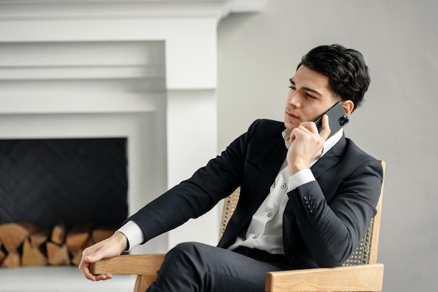 A successful young businessman in an office using a phone