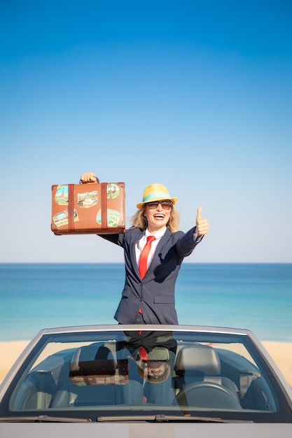 Successful young businesswoman on the beach Woman standing in the cabriolet classic car