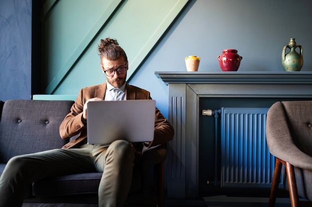 Successful young handsome businessman typing on laptop at workplace