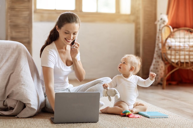 Successful young mother working from home take care of baby