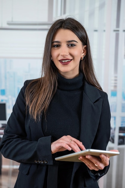 Successful young woman freelancer manager work with phone standing alone at office