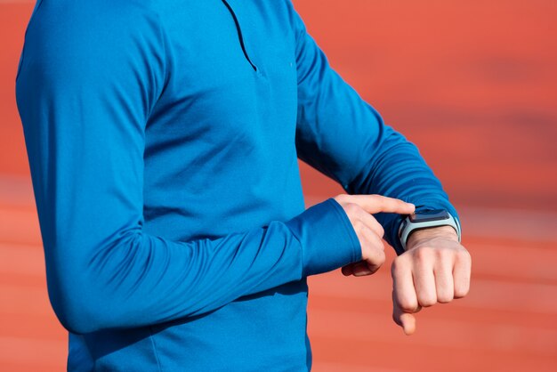 Photo successfully runner looking at heart rate monitor smart watch, close up.