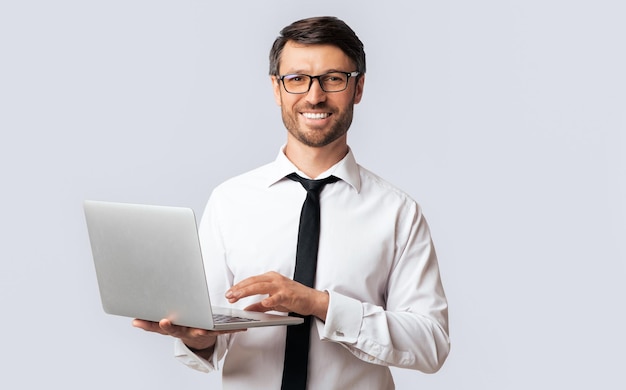 Successsful Man Working On Laptop Standing Over White Background