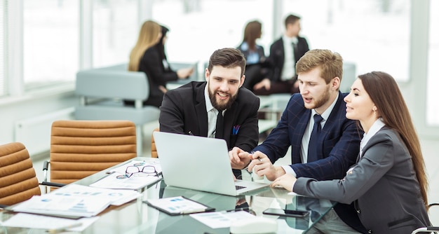 Succesvol commercieel team dat aan laptop werkt en het huidige financiële rapport maakt