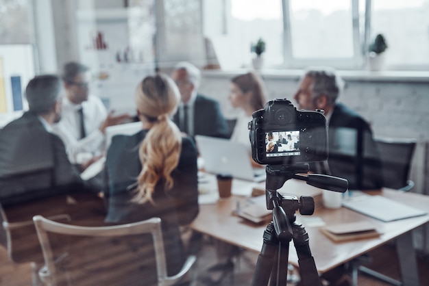 Succesvol zakenteam dat strategie bespreekt tijdens het filmen van de personeelsvergadering in de bestuurskamer