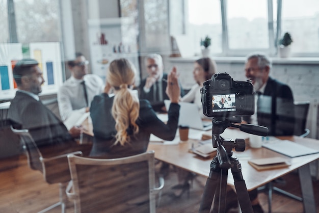 Succesvol zakenteam dat strategie bespreekt tijdens het filmen van de personeelsvergadering in de bestuurskamer