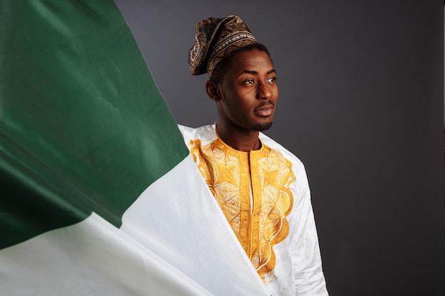 Succesvolle Afrikaanse man winnaar voordat hij met de vlag van Nigeria zwaaide Glimlachend en kijkend naar de camera