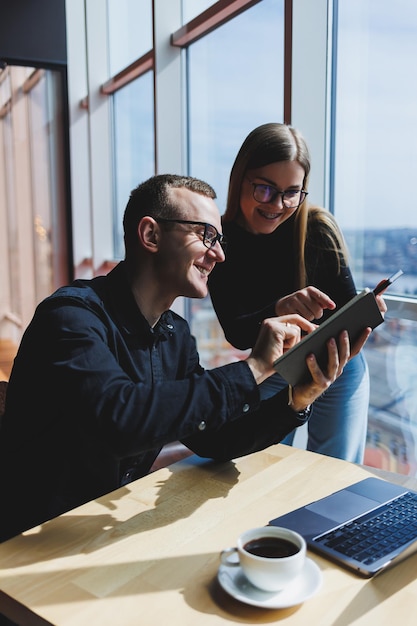 Succesvolle business team mannelijke en vrouwelijke collega's praten op het werk bespreken een nieuw project met een laptop jonge leidinggevenden hebben een vriendelijk gesprek samenwerken aan teamwork op kantoor