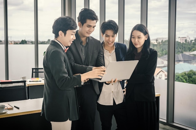 Succesvolle gelukkige werknemers Groep Aziatische zakenmensen met verschillende geslachten (LGBT) zien een succesvol businessplan op de laptopcomputer in de vergaderruimte op kantoor