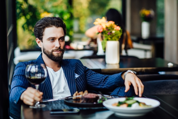 Succesvolle intelligente zakenman ontspannen in een luxe restaurant buitenshuis