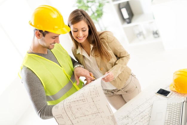 Succesvolle jonge architecten die bouwplannen bespreken en de volgende stap op kantoor plannen.