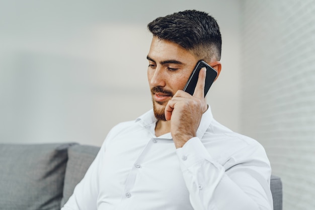 Succesvolle jonge zakenman die op zijn mobiel spreekt