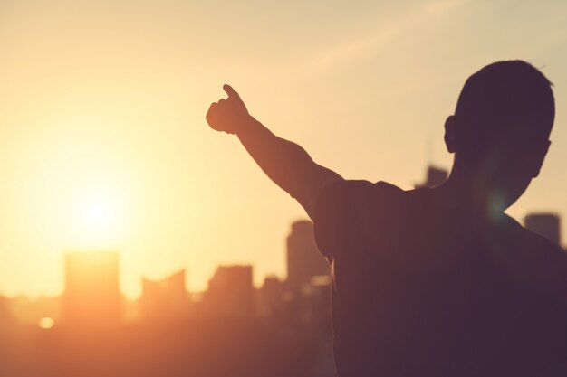 Succesvolle man gericht op zonsondergang