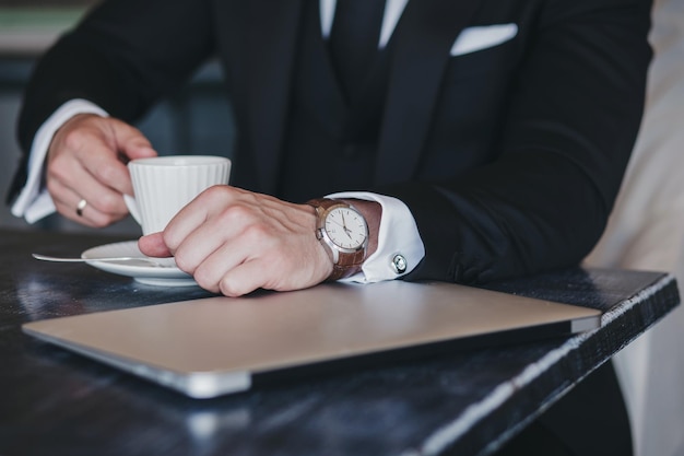 Succesvolle man in een pak in een café Bedrijfsconcept Digitale tablet en kopje koffie op bureau