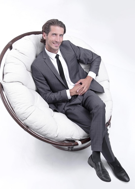 Succesvolle man zit in de grote witte stoelfoto met kopieerruimte