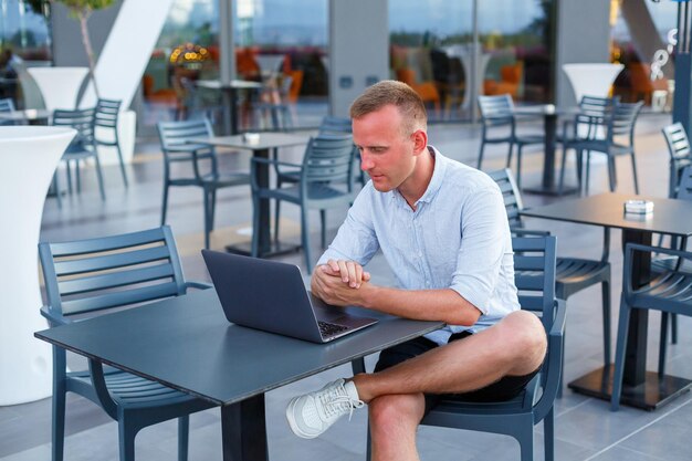 Succesvolle mannelijke freelance zakenman met behulp van laptopcomputer op het werk op vakantie. Zaken, studie, freelance. Afstandswerk