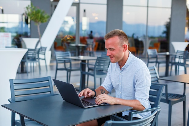 Succesvolle mannelijke freelance zakenman met behulp van laptopcomputer op het werk op vakantie. Zaken, studie, freelance. Afstandswerk
