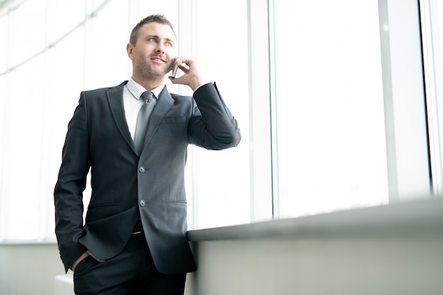 Succesvolle mannelijke ondernemer praten over de telefoon