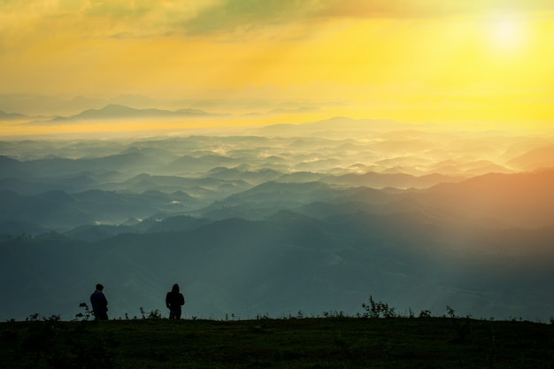 Succesvolle mensenwandelaar op hoogste berg - Mens die zich op heuvel met zonsopgang bevindt