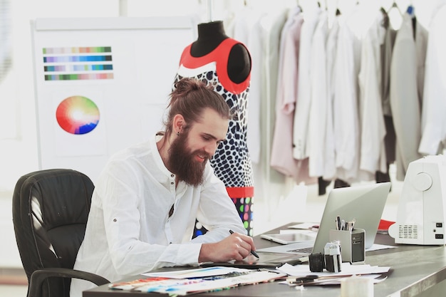 Succesvolle ontwerper werkt aan nieuwe kledingschetsen