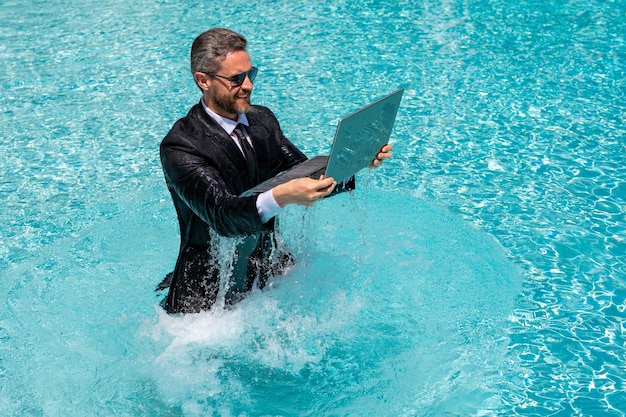 Succesvolle opgewonden zakenman in pak in zwembadwater zomervakanties en zakenreisconcept f