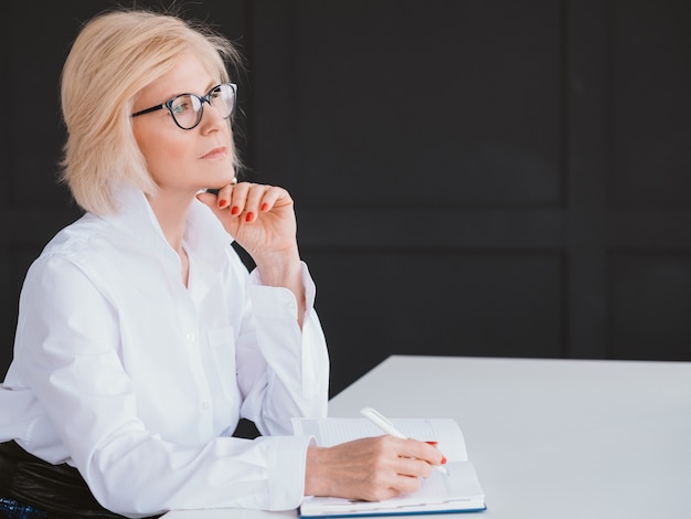 succesvolle oude dame. vrouwelijke kracht. lachende zakenvrouw op de werkplek