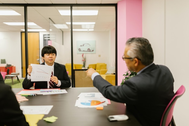 Succesvolle oudere zakenman met zijn team die in een modern kantoor werkt