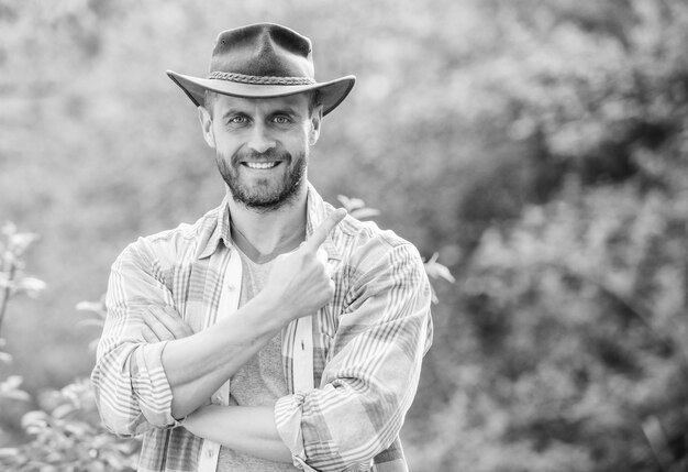 Succesvolle sexy boer Eco-landbouwer Oogst gelukkige aardedag Eco-levende landbouw en landbouwteelt Tuinieren ranch gespierde ranch man in cowboyhoed zorgplanten Wereld groen maken