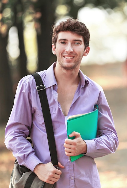 Succesvolle student met boeken in het Park op een zonnige dag.