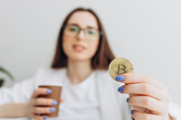 Succesvolle vrouw met gouden bitcoin in haar hand