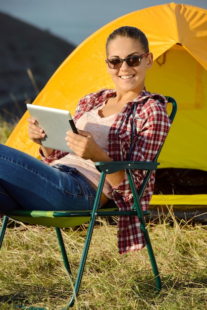 Succesvolle vrouw met tabletzitting als vouwende voorzitter.