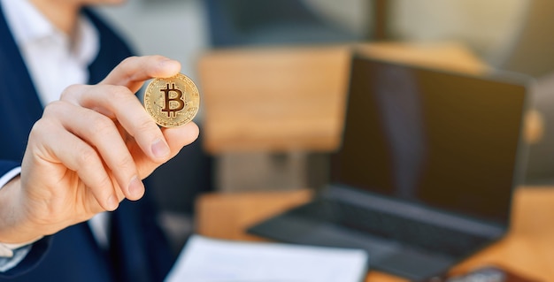 Succesvolle zakenman houdt een gouden bitcoin-muntstuk in zijn hand. Cryptocurrency bedrijfsconcept