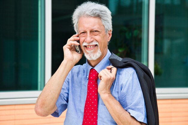 Succesvolle zakenman spreekt op zijn smartphone