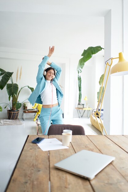 Succesvolle zakenvrouw danst in kantoorkleding en viert vrolijk op het werk vrouwelijke kantoormedewerker